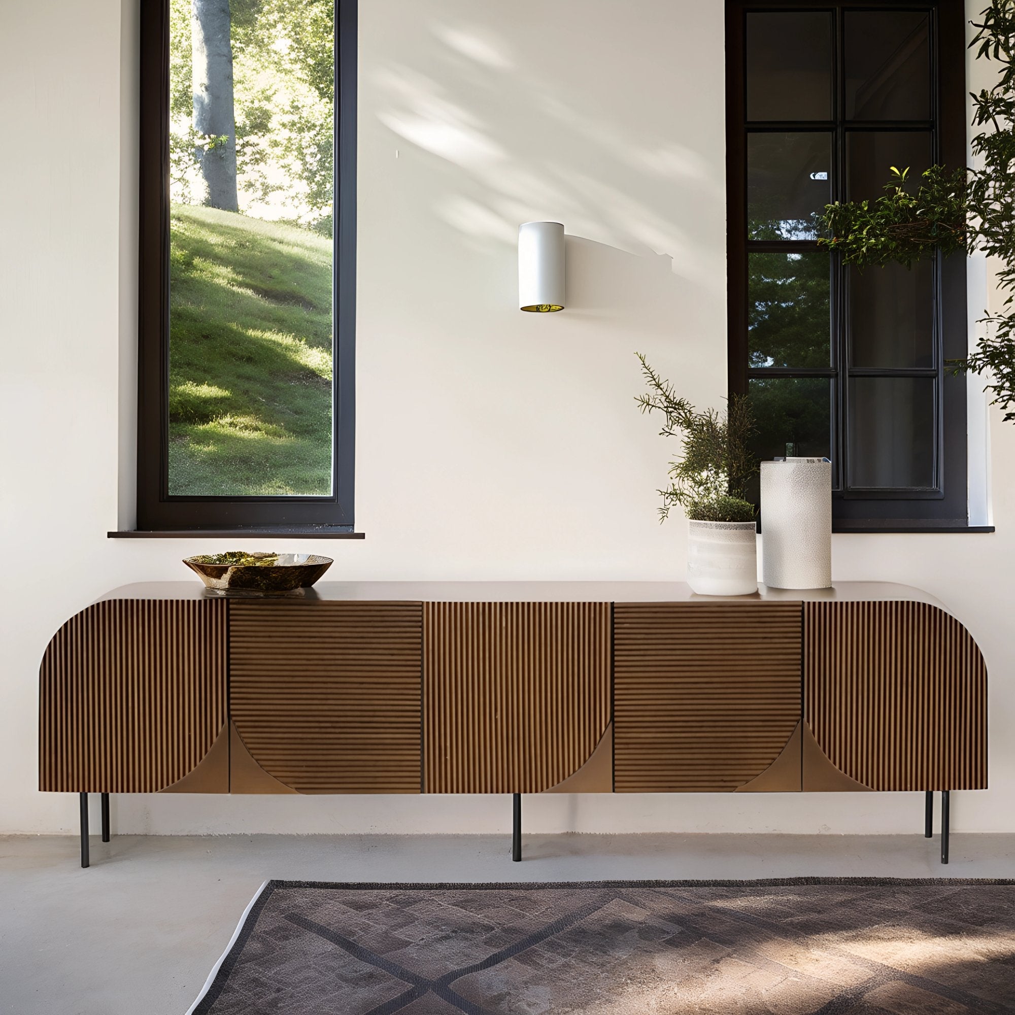 Buffet en hêtre au design naturel et chaleureux, décoré de plantes en pot et d’éléments en céramique dans un intérieur épuré.