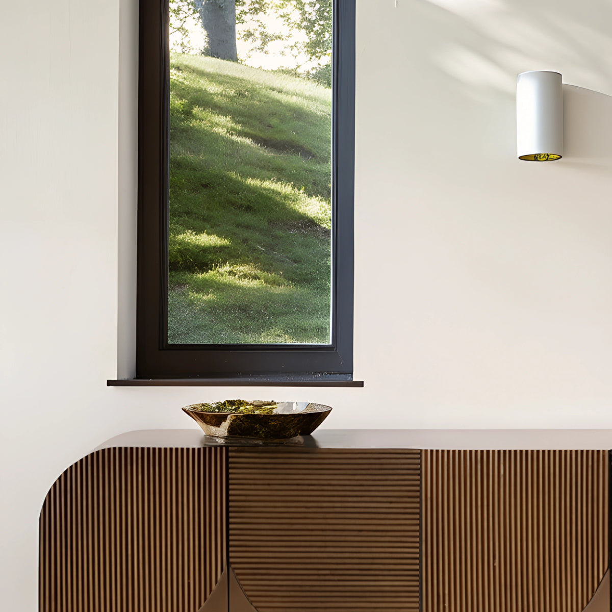 Buffet en hêtre au design naturel et chaleureux, décoré de plantes en pot et d’éléments en céramique dans un intérieur épuré.