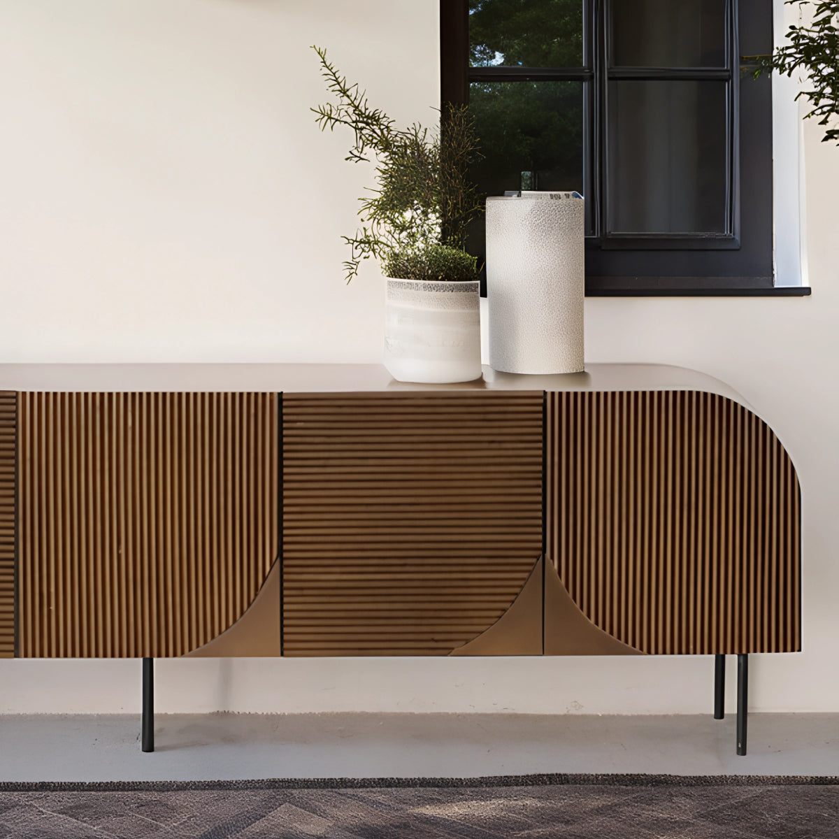 Buffet en hêtre au design naturel et chaleureux, décoré de plantes en pot et d’éléments en céramique dans un intérieur épuré.