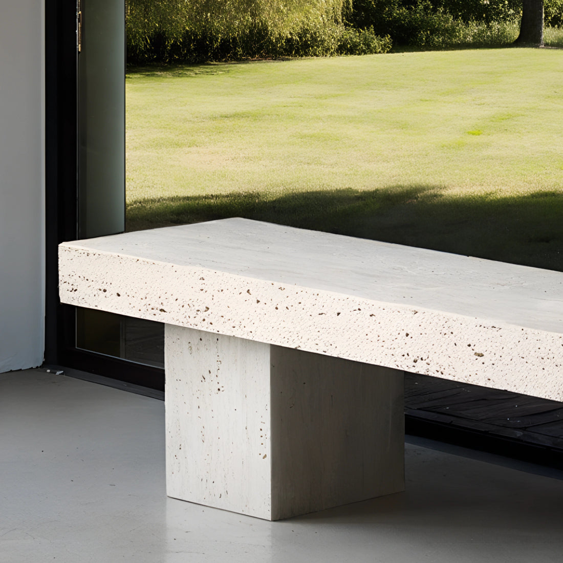 Banc en travertin aux tons beige naturels, aux lignes épurées et minimalistes, disposé dans un intérieur contemporain avec tapis texturé et décoration en céramique.