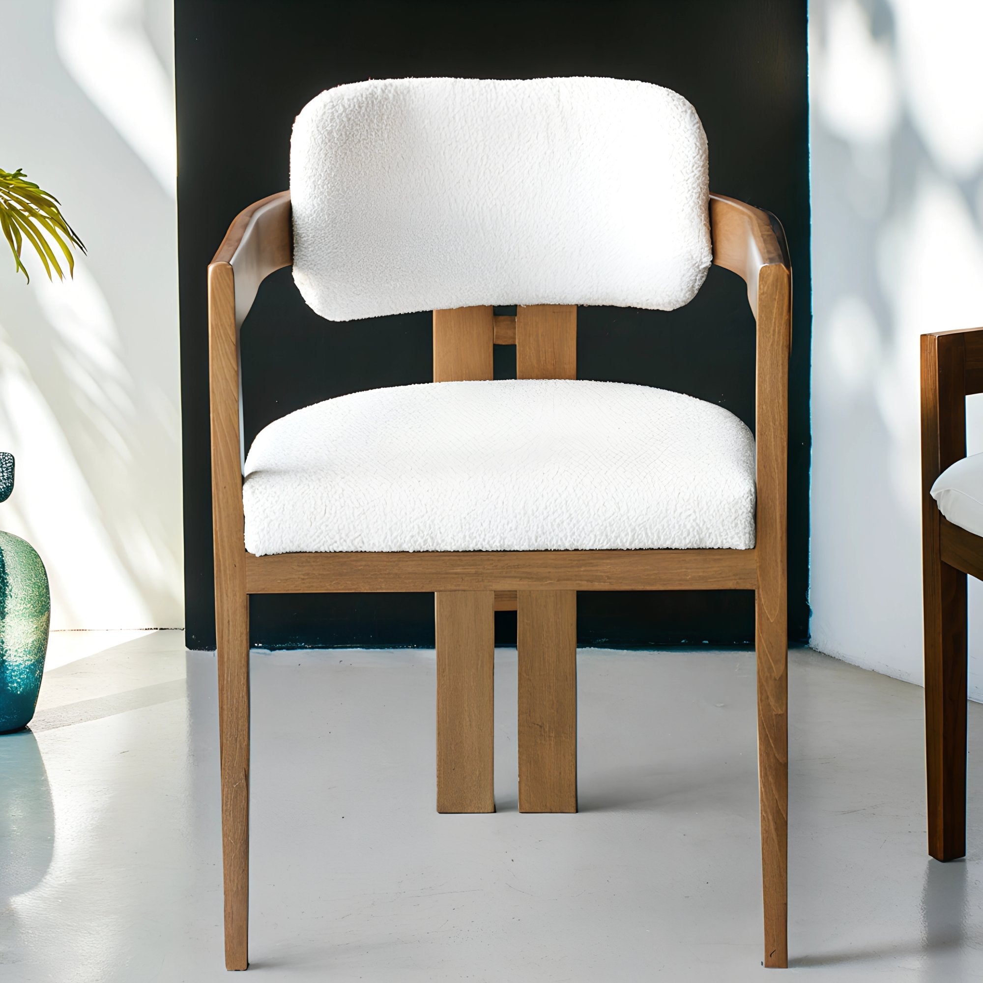 Chaise en bois avec assise en tissu bouclette, alliant chaleur naturelle et douceur texturée pour un confort enveloppant et un design élégant.