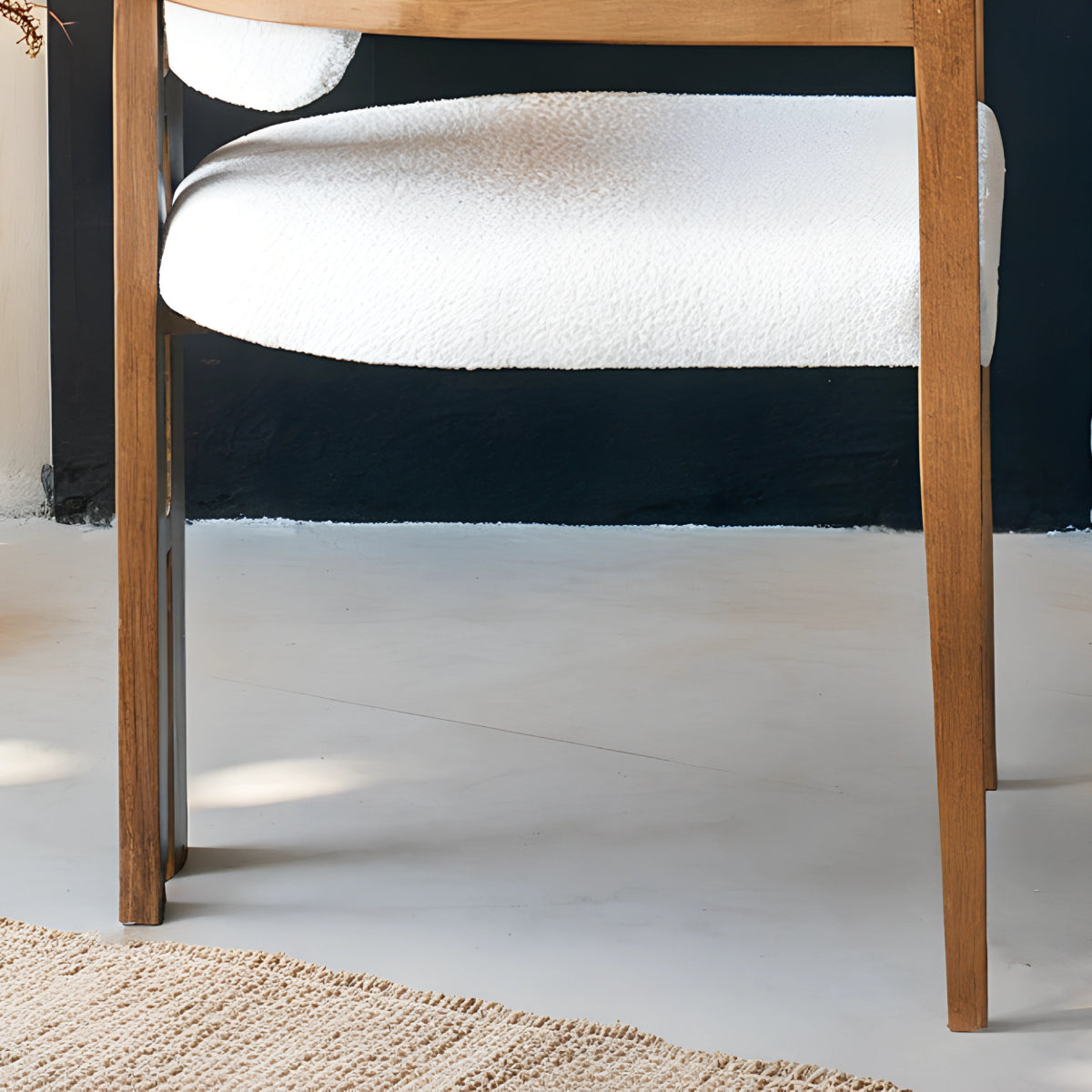 Chaise en bois avec assise en tissu bouclette, alliant chaleur naturelle et douceur texturée pour un confort enveloppant et un design élégant. 
