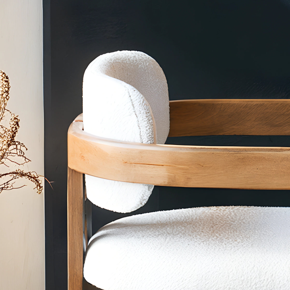 Chaise en bois avec assise en tissu bouclette, alliant chaleur naturelle et douceur texturée pour un confort enveloppant et un design élégant. 