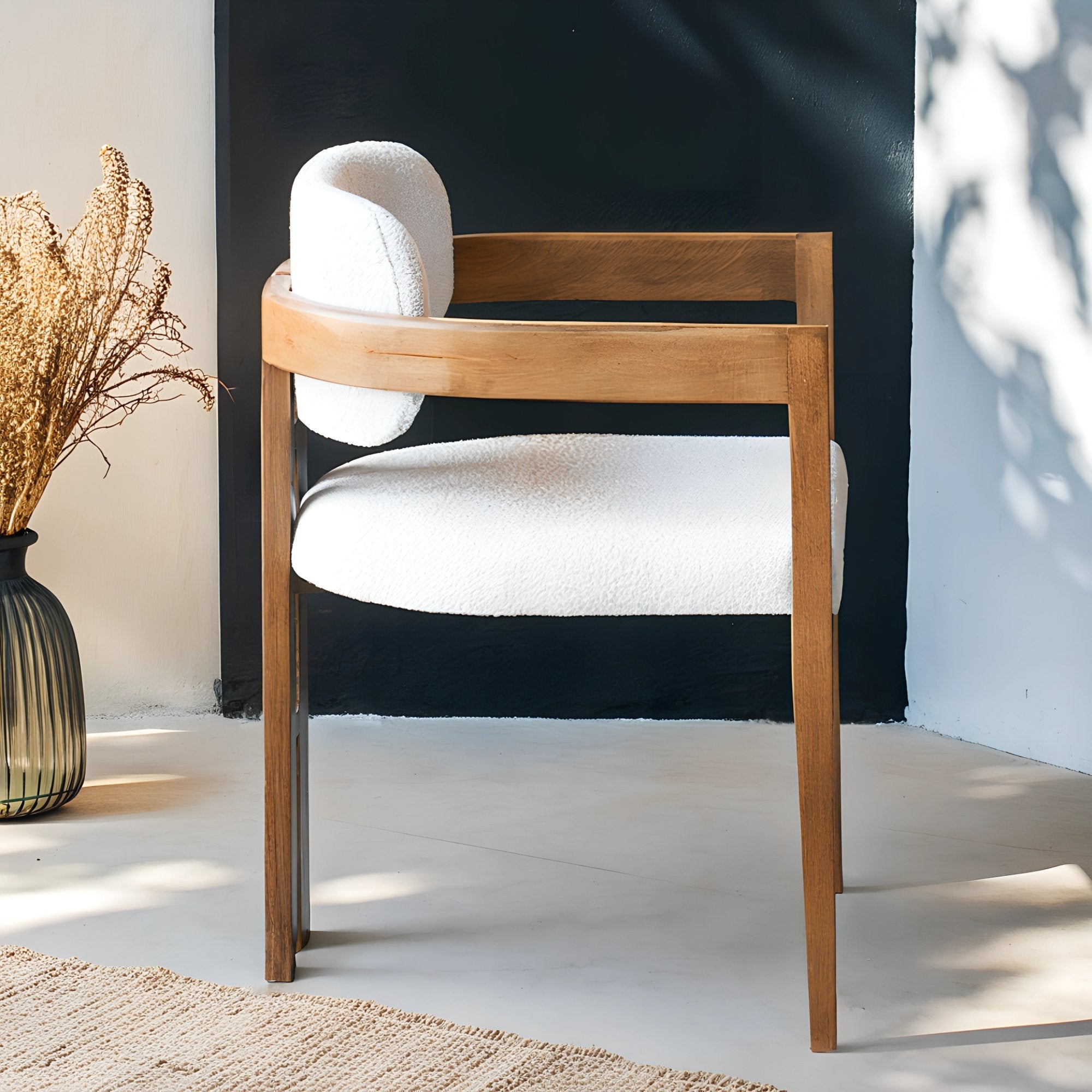 Chaise en bois avec assise en tissu bouclette, alliant chaleur naturelle et douceur texturée pour un confort enveloppant et un design élégant.