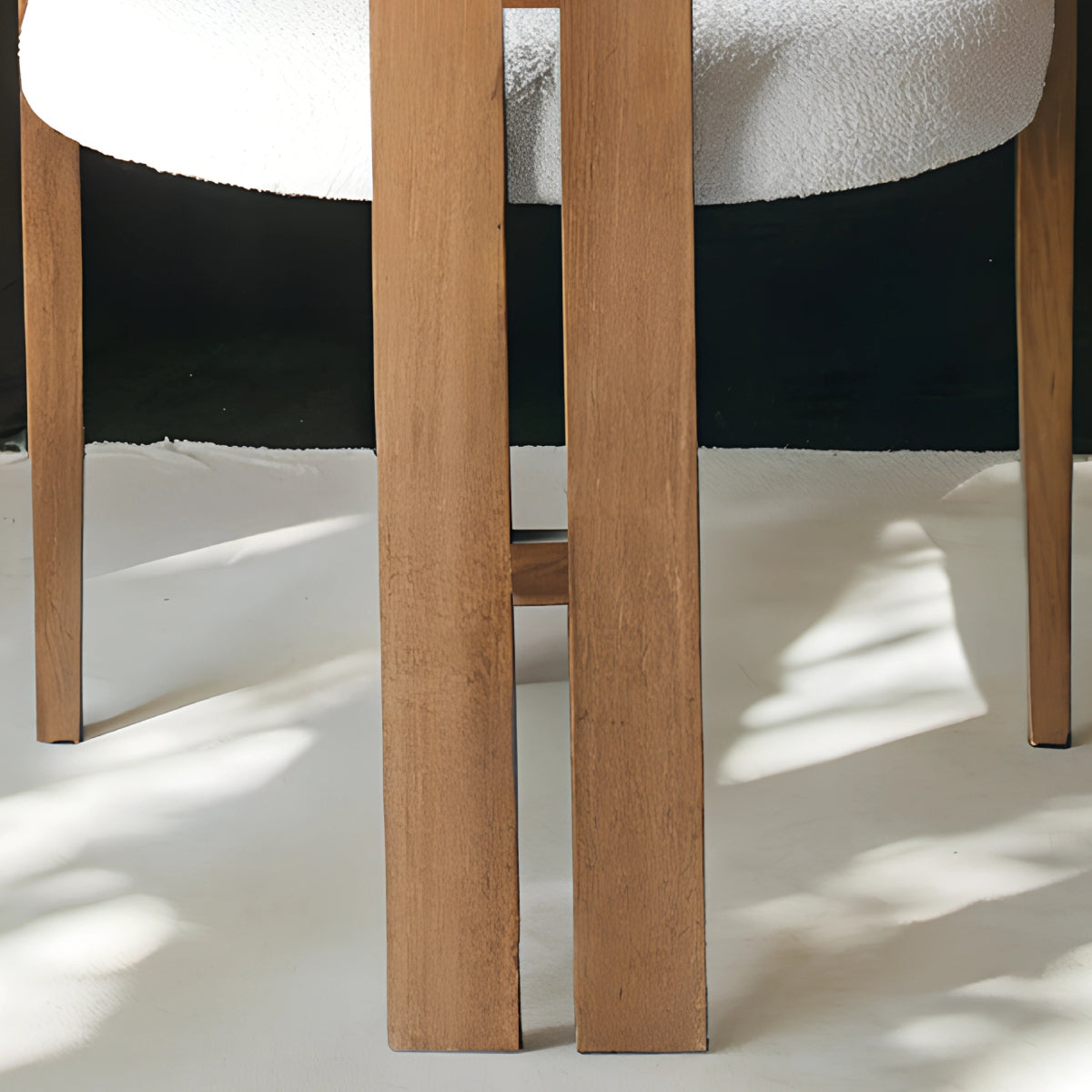 Chaise en bois avec assise en tissu bouclette, alliant chaleur naturelle et douceur texturée pour un confort enveloppant et un design élégant.