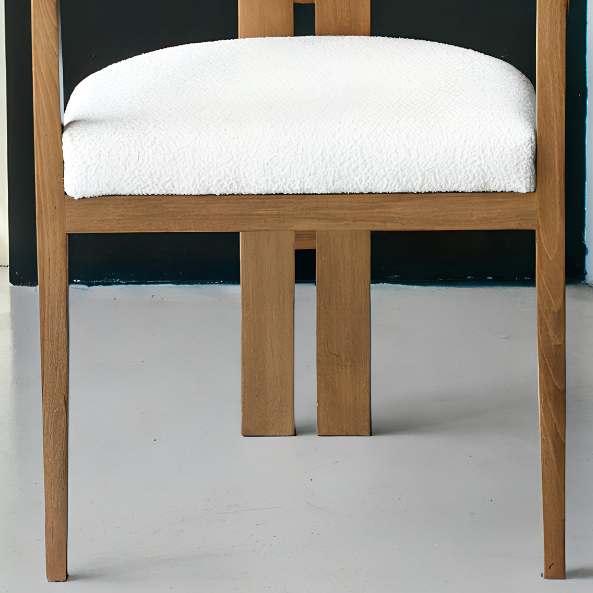 Chaise en bois avec assise en tissu bouclette, alliant chaleur naturelle et douceur texturée pour un confort enveloppant et un design élégant. 