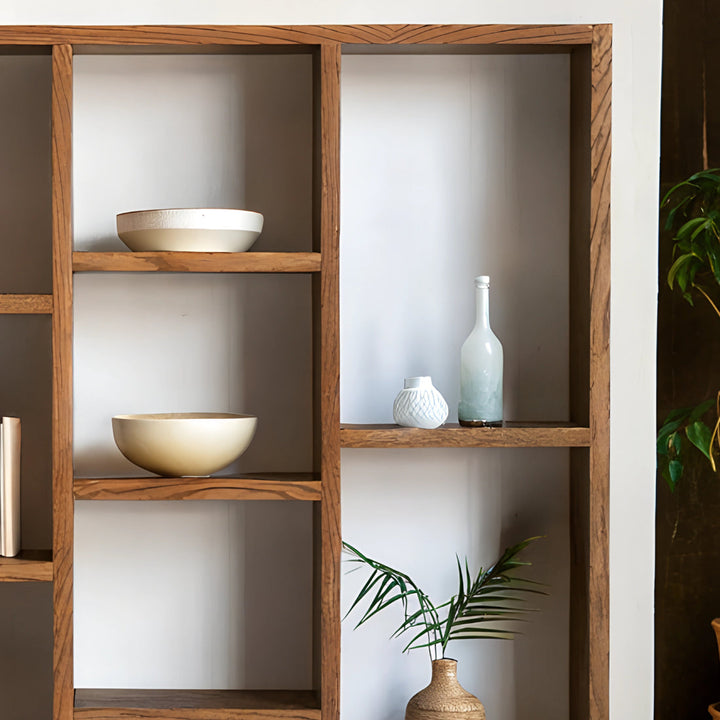 Bibliothèque en chêne au design intemporel, ornée de livres soigneusement disposés et de plantes vertes pour une ambiance chaleureuse et naturelle.