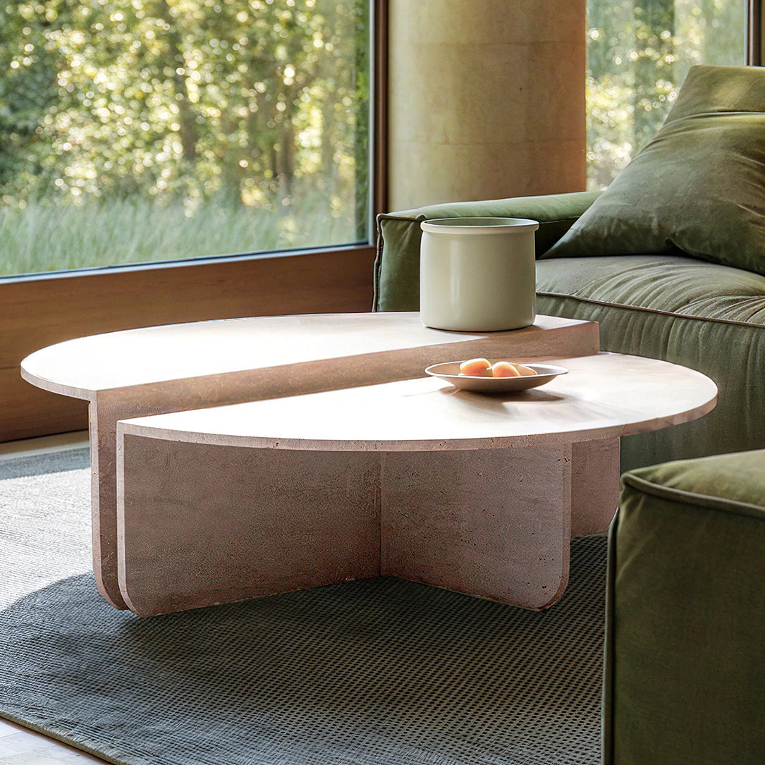 Table basse en travertin au design épuré et intemporel, mise en scène avec des livres et des objets décoratifs en céramique.