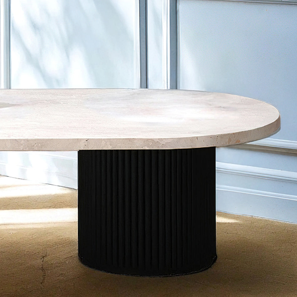 Table basse en travertin et bois noir, contrastant élégance minérale et profondeur boisée, agrémentée de livres et d’objets design.