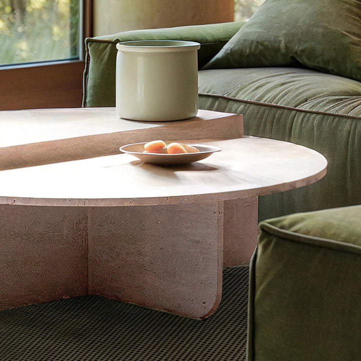 Table basse en travertin au design épuré et intemporel, mise en scène avec des livres et des objets décoratifs en céramique.