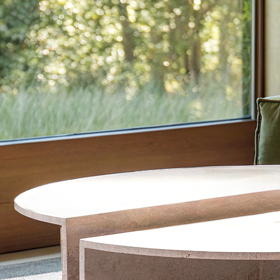Table basse en travertin au design épuré et intemporel, mise en scène avec des livres et des objets décoratifs en céramique.