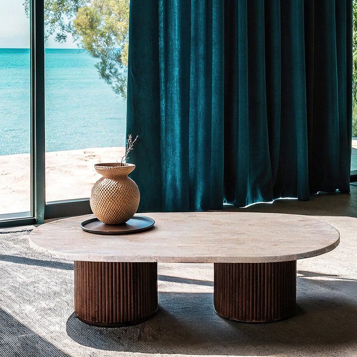 Table basse alliant bois et travertin, au design harmonieux et naturel, agrémentée de livres et d’objets décoratifs minimalistes.